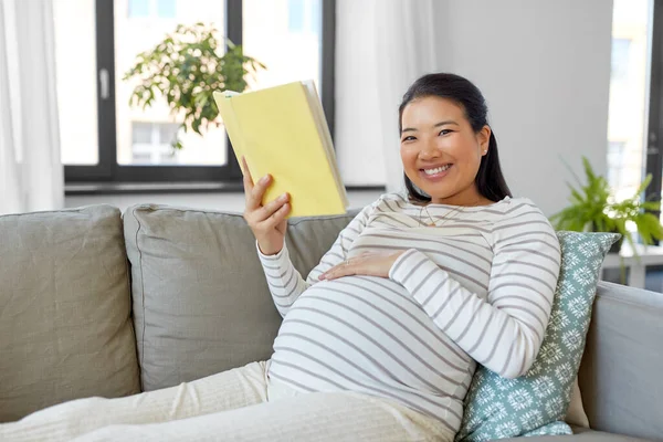 Gelukkig zwanger vrouw lezen boek thuis — Stockfoto