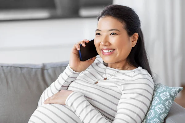 Mulher grávida feliz chamando no smartphone em casa — Fotografia de Stock