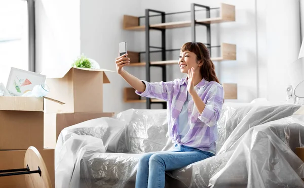 Woman having video call and moving into new home — Stock Photo, Image