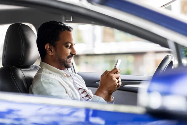 Souriant homme indien en voiture en utilisant un smartphone — Photo