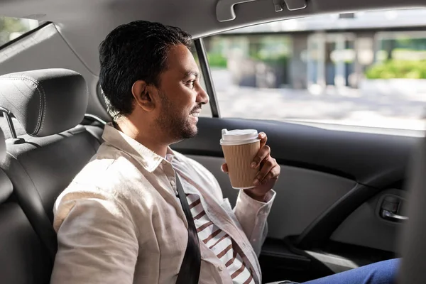 Indianin z kawą na wynos na tylnym siedzeniu samochodu — Zdjęcie stockowe