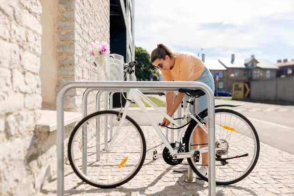 Donna parcheggiare la bicicletta sulla strada della città — Foto Stock