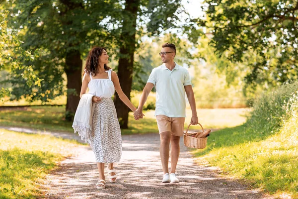 Pareja feliz con cesta de picnic en el parque de verano —  Fotos de Stock