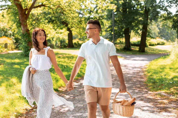 Lyckligt par med picknickkorg på sommarparken — Stockfoto