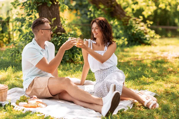 Casal feliz fazendo piquenique no parque de verão — Fotografia de Stock