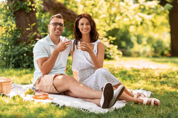 Feliz pareja teniendo un picnic en el parque de verano —  Fotos de Stock