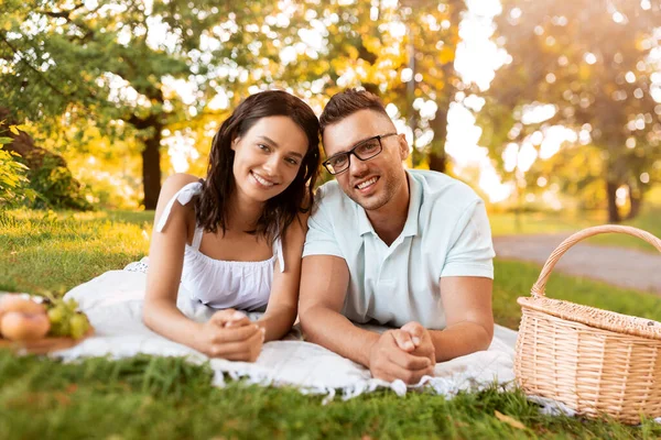 Pareja feliz en manta de picnic en el parque de verano — Foto de Stock