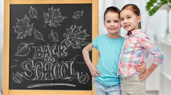 Niñas estudiantes sobre pizarra escolar — Foto de Stock