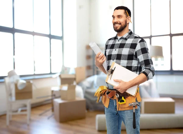 Constructor masculino con portapapeles y plano en casa — Foto de Stock