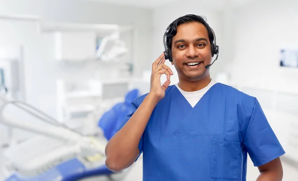 Médico indio con auriculares en el consultorio dental —  Fotos de Stock