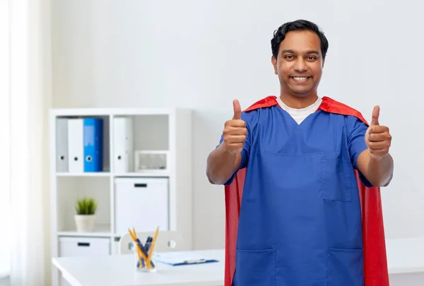 Mužský lékař v plášti superhrdiny ukazující palce nahoru — Stock fotografie