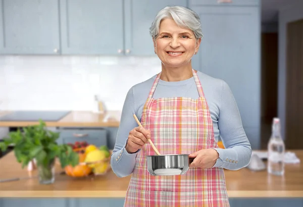 Idős nő kötényben pot főzés élelmiszer — Stock Fotó