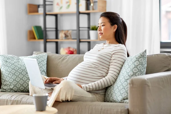 Enceinte asiatique femme avec ordinateur portable à la maison — Photo