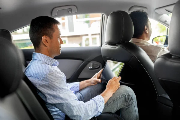 Passager masculin avec tablette dans une voiture de taxi — Photo