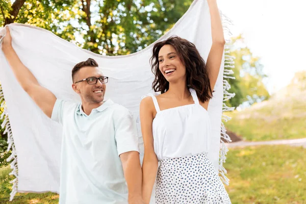 Gelukkig paar met picknick deken in zomerpark — Stockfoto