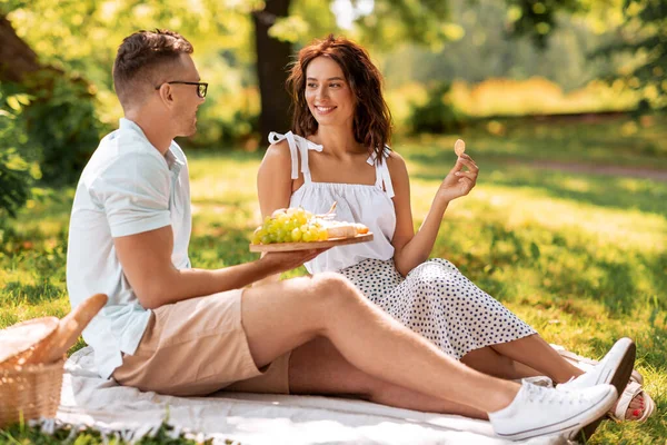 Feliz pareja teniendo un picnic en el parque de verano —  Fotos de Stock