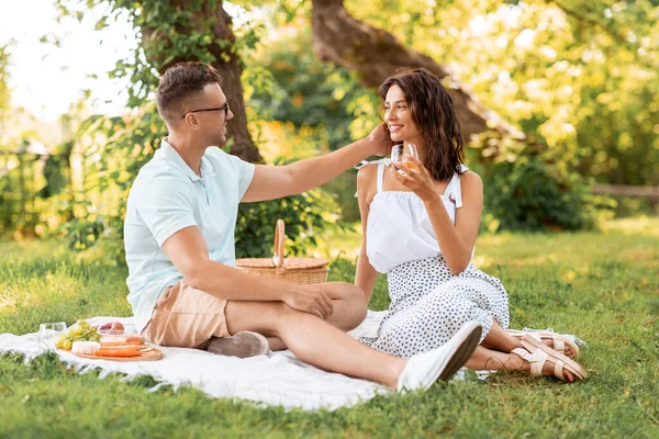 Happy couple having picnic at summer park — Stock Photo, Image