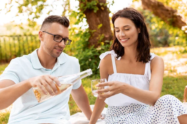 Şaraplı mutlu çift parkta piknik yapıyor. — Stok fotoğraf