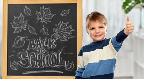 Pequeño estudiante mostrando pulgares hacia arriba —  Fotos de Stock