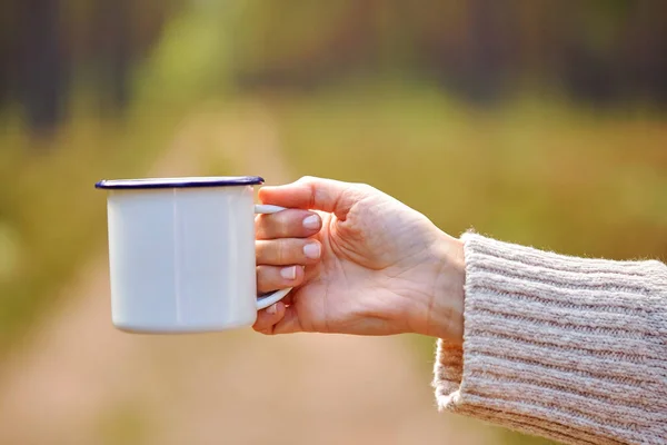 森の中に白いティーマグカップを持つ女性の手 — ストック写真