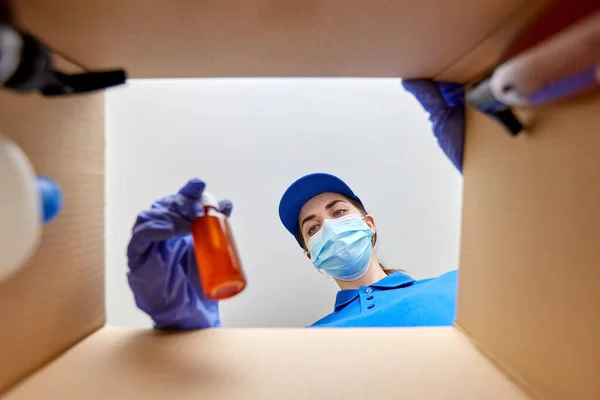 Femme dans masque emballage boîte de colis avec des cosmétiques — Photo