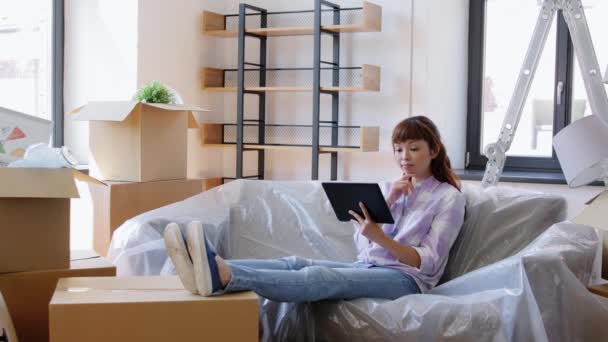 Aziatische vrouw met tablet pc verhuizen naar nieuw huis — Stockvideo