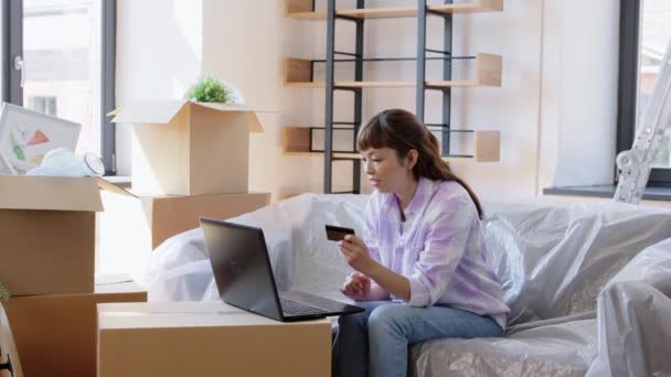 Donna con computer portatile e carta di credito nella nuova casa — Video Stock