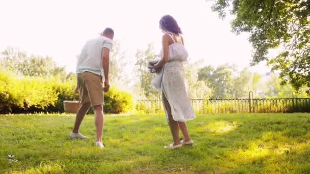 Happy couple laying picnic blanket at summer park — Stock Video