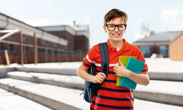 Smiling student boy with backpack and books — Stock Photo, Image