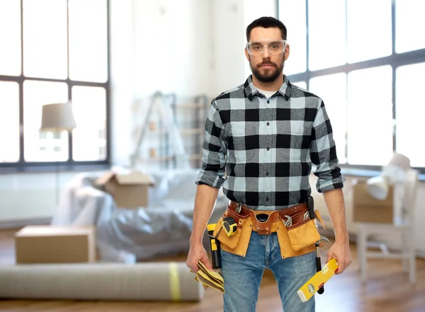 Construtor masculino com ferramentas e nível em casa — Fotografia de Stock