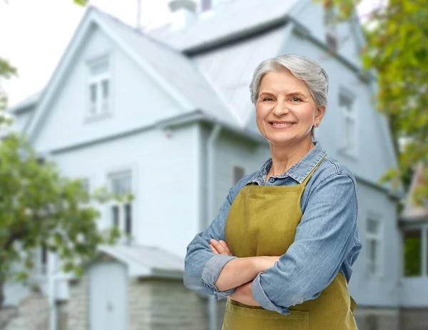 Portrait of smiling senior woman in garden apron — Stock Photo, Image