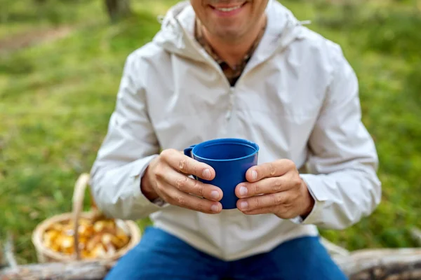 Hombre con cesta de setas bebe té en el bosque — Foto de Stock