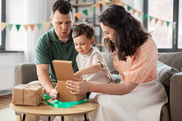 Glad familj öppna födelsedagspresenter hemma — Stockfoto