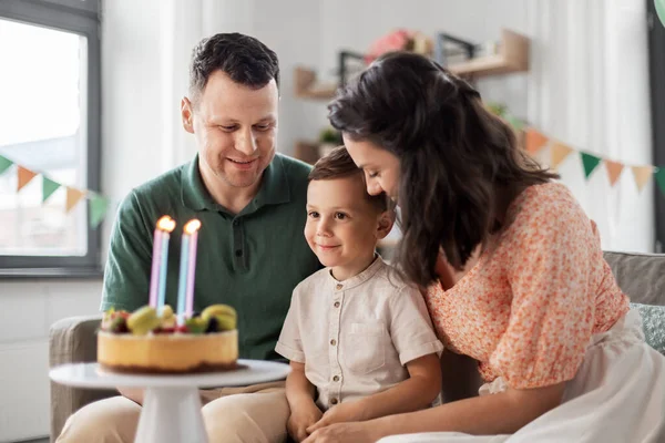 Glückliche Familie mit Geburtstagstorte zu Hause — Stockfoto