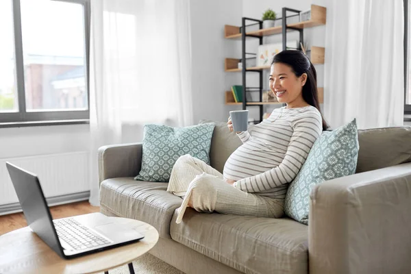 Feliz embarazada asiático mujer con portátil en casa — Foto de Stock