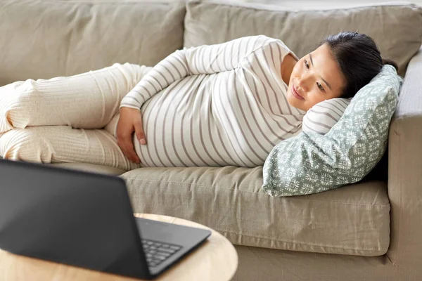 Happy pregnant asian woman with laptop at home — Stock Photo, Image