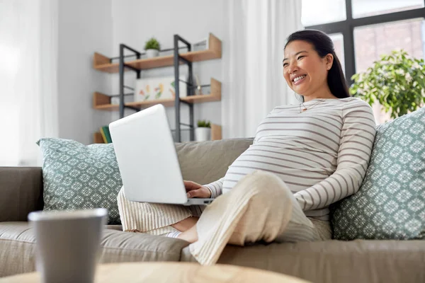 Feliz embarazada asiático mujer con portátil en casa — Foto de Stock