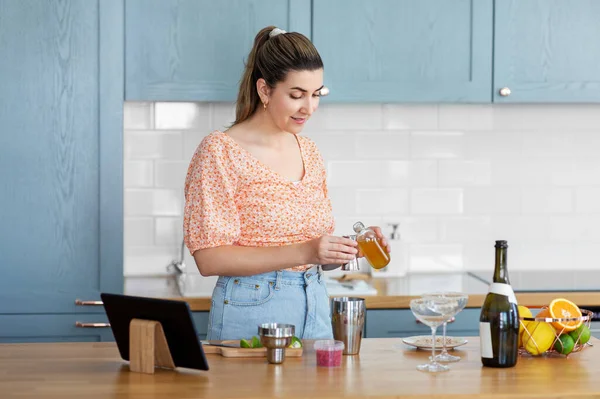 Mujer con tablet pc haciendo cócteles en la cocina —  Fotos de Stock