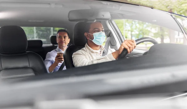 Mannelijke bestuurder in masker rijden auto met passagier — Stockfoto