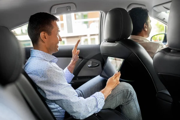 Man met tablet pc met videogesprek in taxiauto — Stockfoto