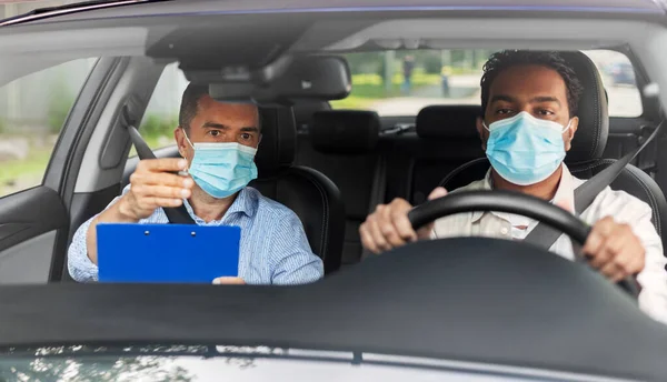 car driving school instructor and driver in mask