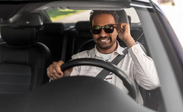 Smiling indian man in sunglasses driving car — Stock Photo, Image