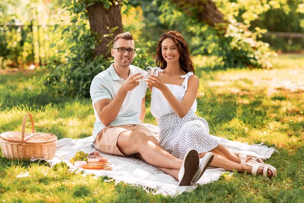 Feliz pareja teniendo un picnic en el parque de verano —  Fotos de Stock