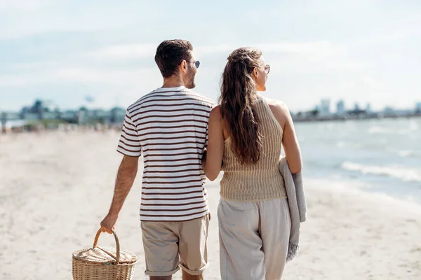 Щаслива пара з кошиком для пікніка, що йде на пляжі — стокове фото