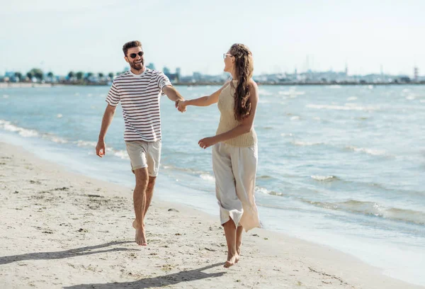 Casal feliz correndo ao longo da praia de verão — Fotografia de Stock