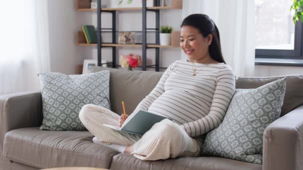 Donna incinta che scrive al diario a casa — Video Stock