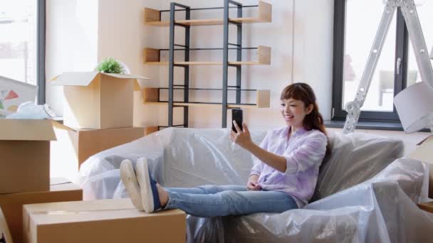 Vrouw met telefoon met video bellen in nieuw huis — Stockvideo