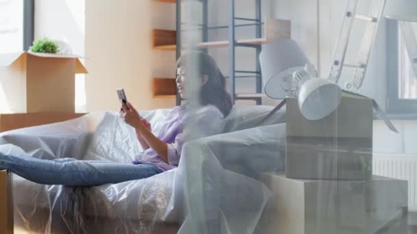 Mujer con teléfono que tiene videollamada en casa nueva — Vídeos de Stock