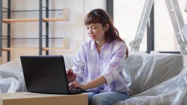 Femme avec ordinateur portable déménageant dans une nouvelle maison — Video