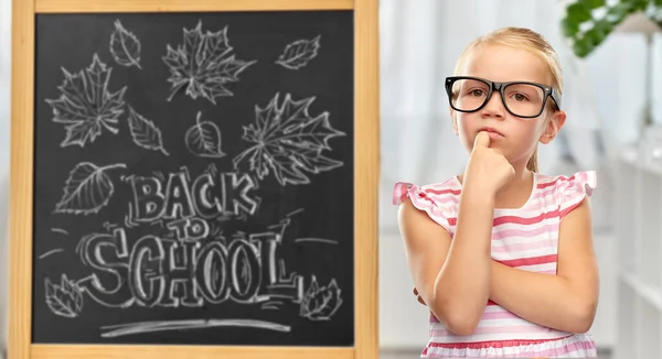 Kleines Studentenmädchen mit Brille denkt nach — Stockfoto